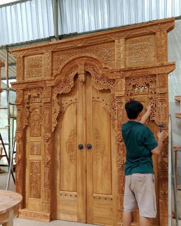 Hand-carved teak double door with a carved frame, Bali handicraft