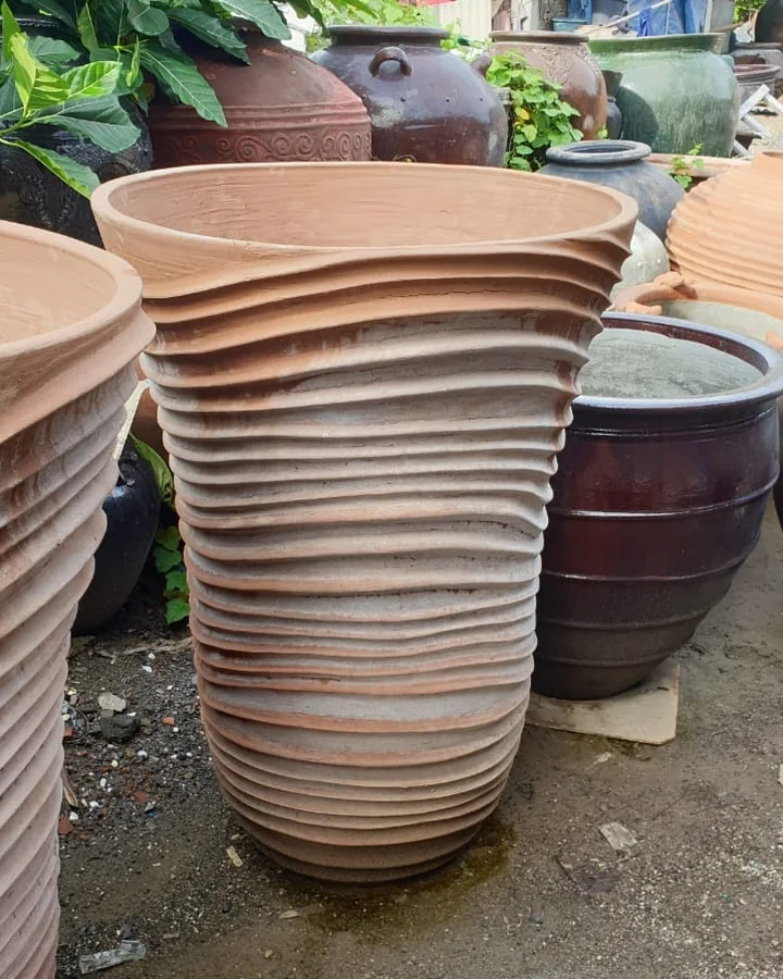 Stacked ribbed terracotta garden pots at a Bali pottery workshop