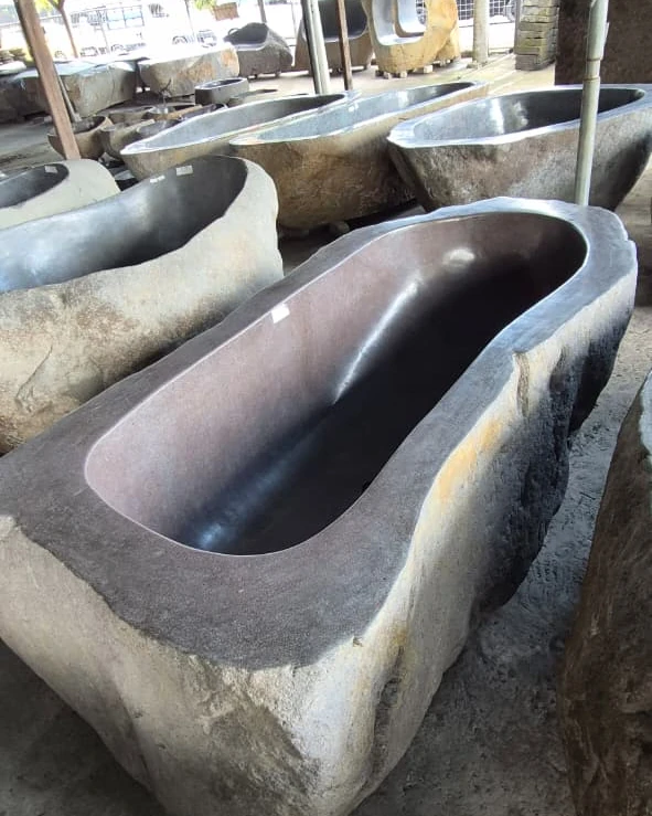 Row of river stone bathtubs at a supplier's stone yard