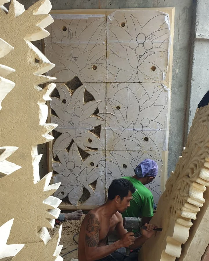 Stone carvers working on floral panels in a Bali carving workshop